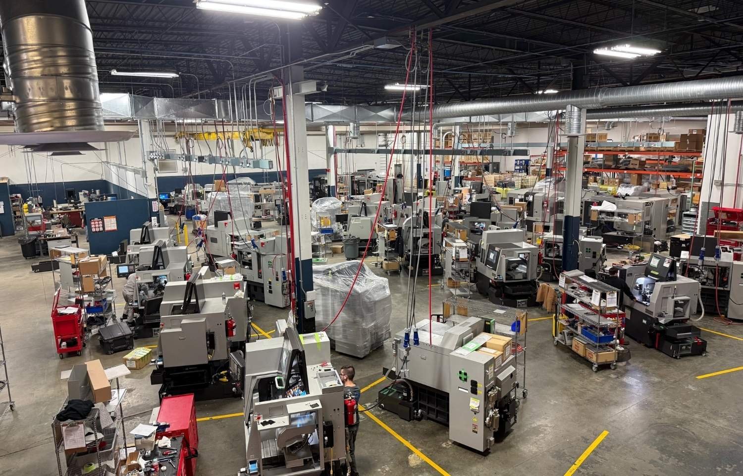 Tsugami America Make Ready and Process Development Center floor with multiple small parts CNC machines being prepared and tested before shipment